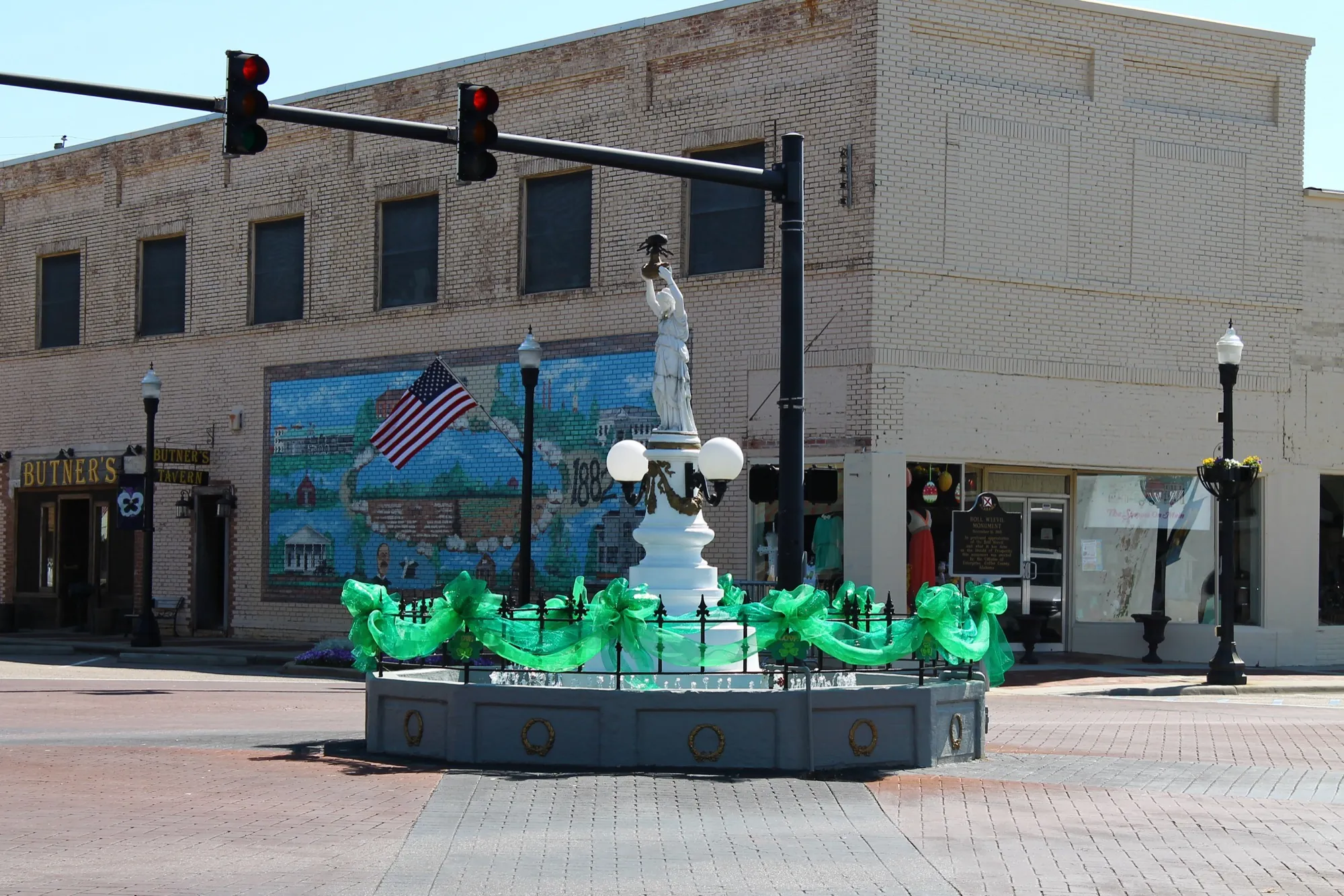 Downtown Enterprise square with the Boll Weevil Monument and a painted mural on a brick building