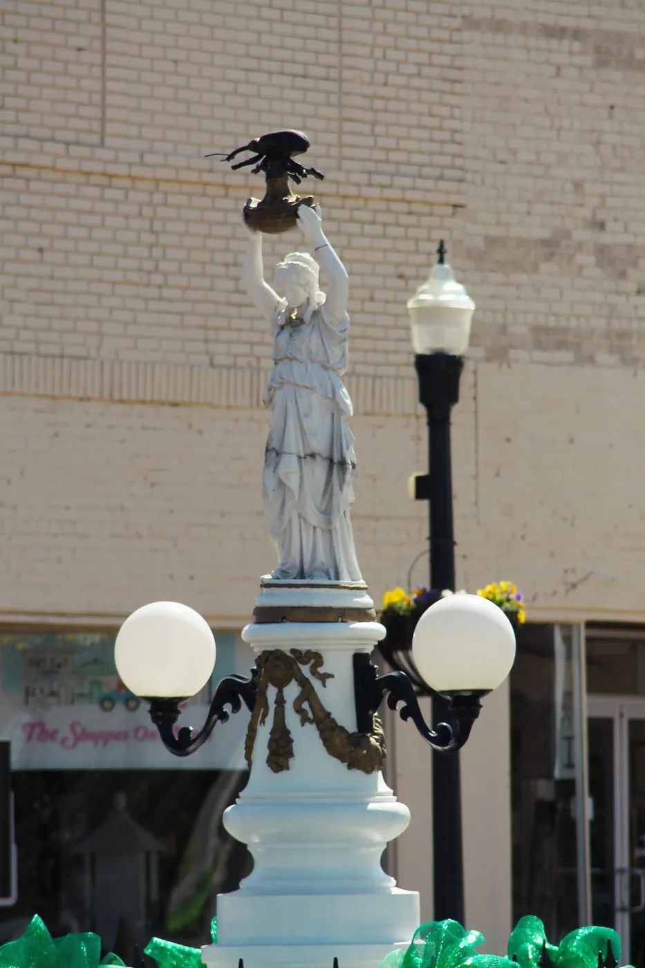 The Boll Weevil Monument with its lamp posts, looking up from the square